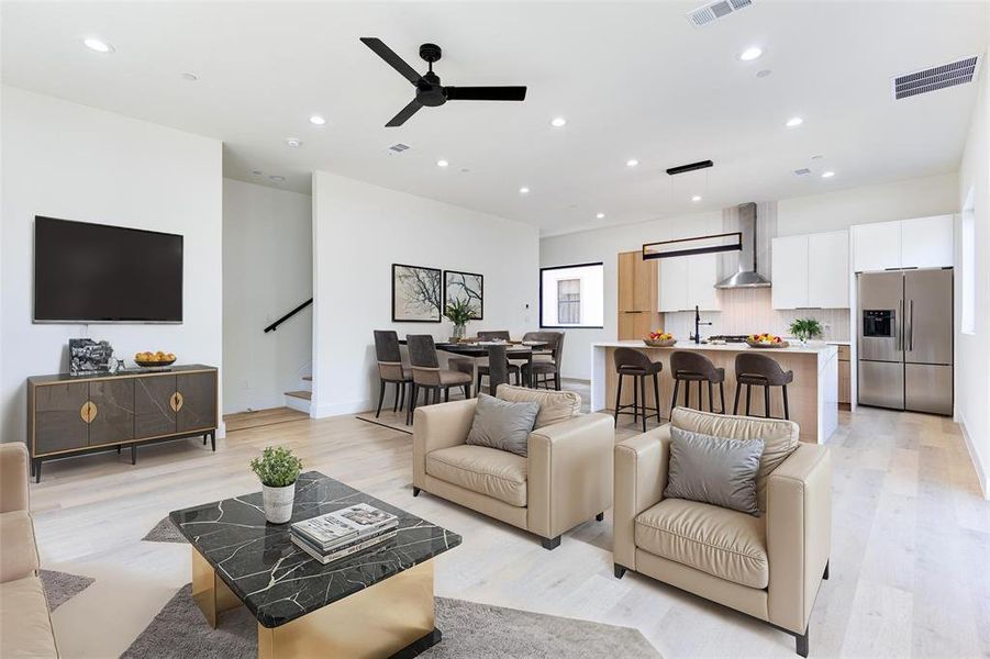 Living room featuring ceiling fan, sink, and light hardwood / wood-style floors