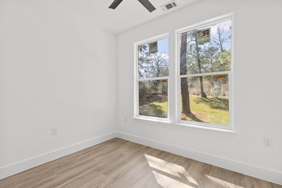 Spare room with light wood finished floors and ceiling fan