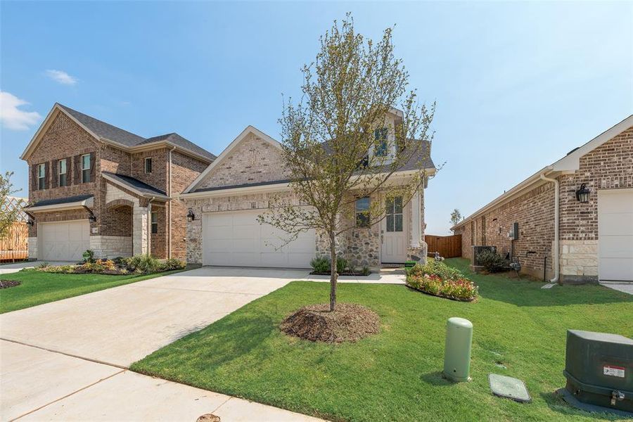 Front exterior of a new home in Spiritas Ranch, Little Elm, TX, highlighting curb appeal (Image 21). Front exterior of a new home in Spiritas Ranch, Little Elm, TX, highlighting curb appeal (Image 21).