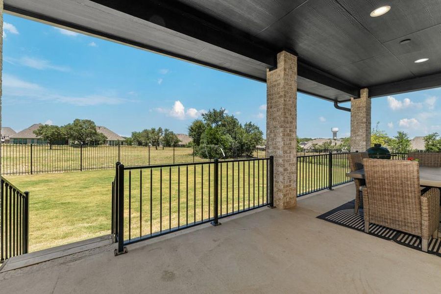 A spacious covered patio offers ample room for outdoor dining and relaxation with serene views of the backyard. A spacious covered patio offers ample room for outdoor dining and relaxation with serene views of the backyard.