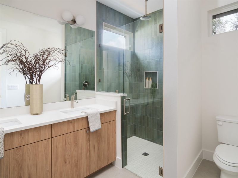 Modern bathroom featuring a dual vanity with wood-finish cabinetry and white countertops