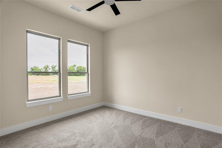 Unfurnished room featuring carpet floors and a ceiling fan Unfurnished room featuring carpet floors and a ceiling fan