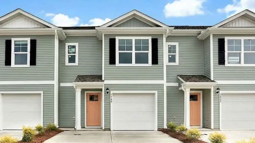 Front exterior of a new home in The Townes at Cedar Hill Landing, Navassa, NC, highlighting curb appeal (Image 1). Front exterior of a new home in The Townes at Cedar Hill Landing, Navassa, NC, highlighting curb appeal (Image 1).