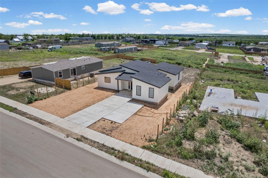 A newly constructed residence features contemporary architecture and a spacious driveway.
