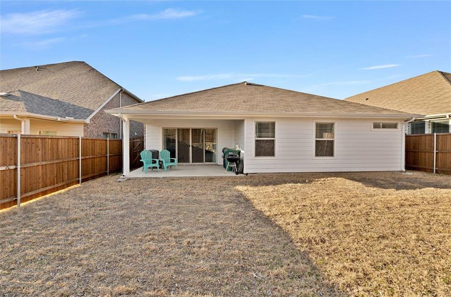 Back of house with a fenced backyard and a patio area