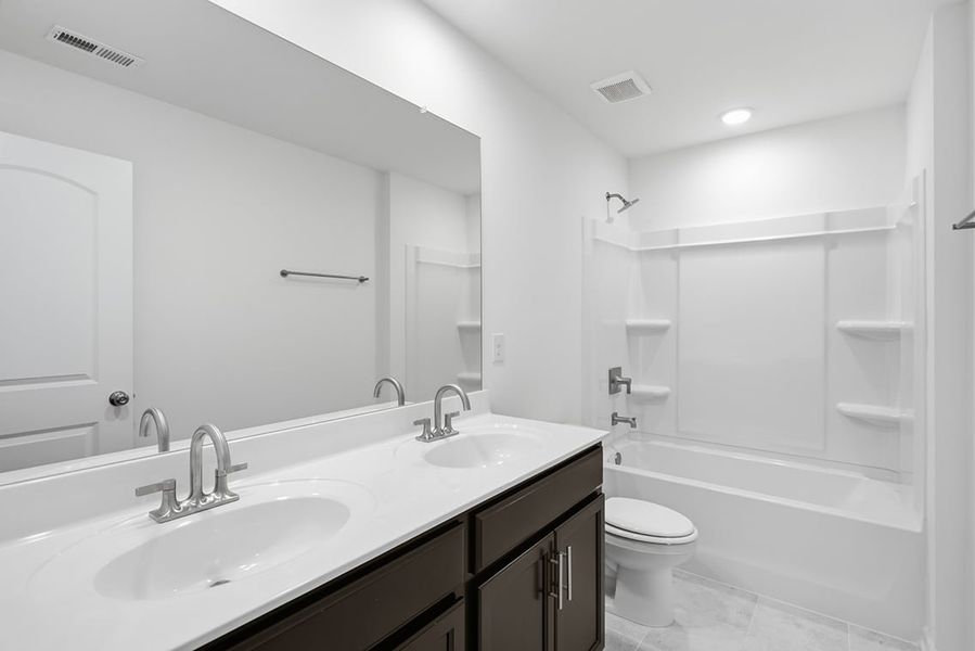 A bathroom with a large mirror. A bathroom with a large mirror.