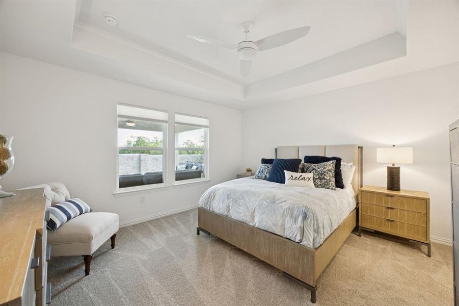 The primary bedroom is in the back of the home for added privacy. Enjoy views of the patio. The tray ceiling adds to the open and spacious feel of the room. Other features of the room are nice size walk-in closet with built-in shelves, carpet, ceiling fan and en suite bath.