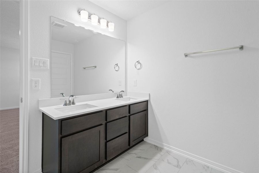 This stunningly updated primary bathroom is truly move-in ready! It features stained cabinetry with light countertops, dual sinks, a large mirror, high ceilings, custom paint, and sleek modern finishes throughout. This stunningly updated primary bathroom is truly move-in ready! It features stained cabinetry with light countertops, dual sinks, a large mirror, high ceilings, custom paint, and sleek modern finishes throughout.