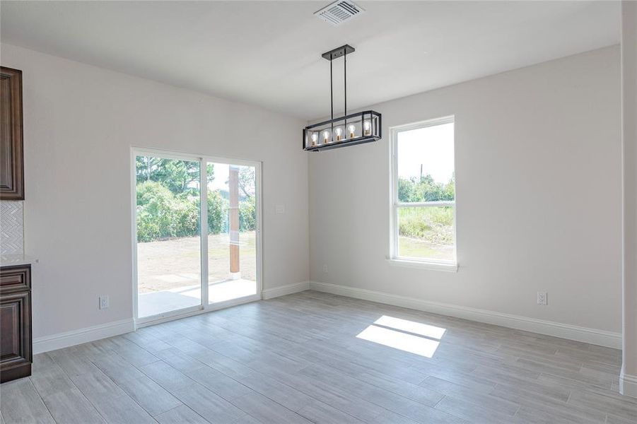 Unfurnished living room with light hardwood / wood-style flooring and a chandelier