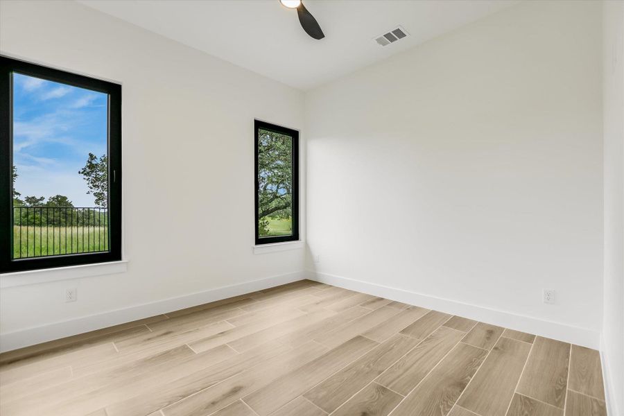 Bright interior room featuring wood-look tile flooring, white baseboards, and white walls