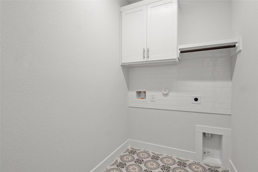 Laundry area featuring electric dryer hookup, cabinet space, and washer hookup Laundry area featuring electric dryer hookup, cabinet space, and washer hookup