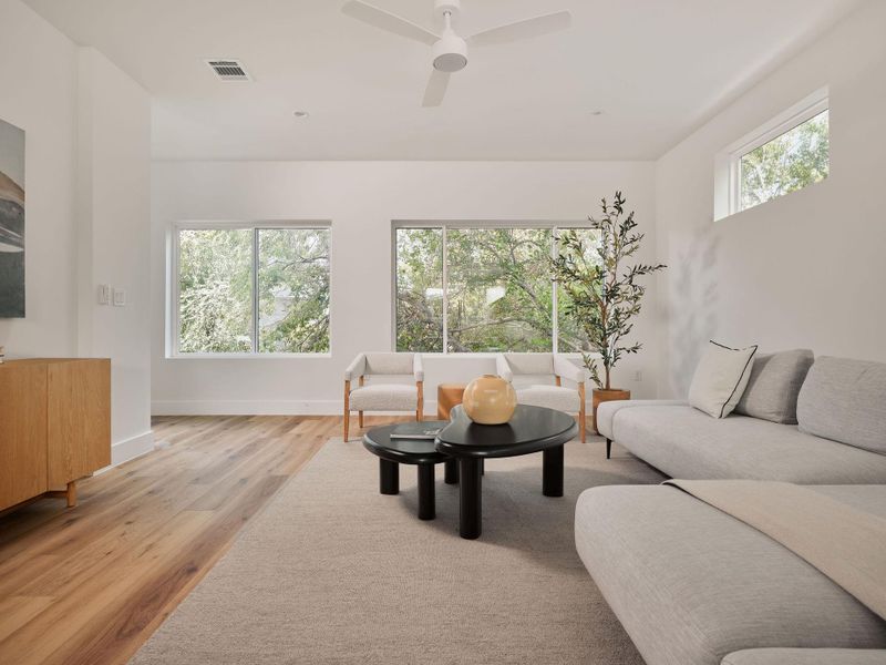 Living area with light wood-type flooring and a ceiling fan