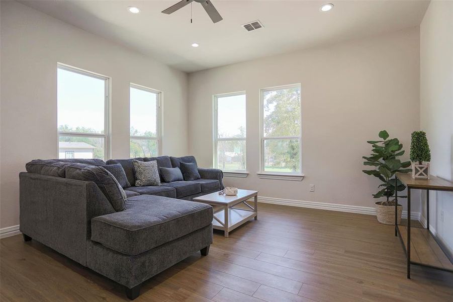 Living room with ceiling fan and dark hardwood / wood-style floors