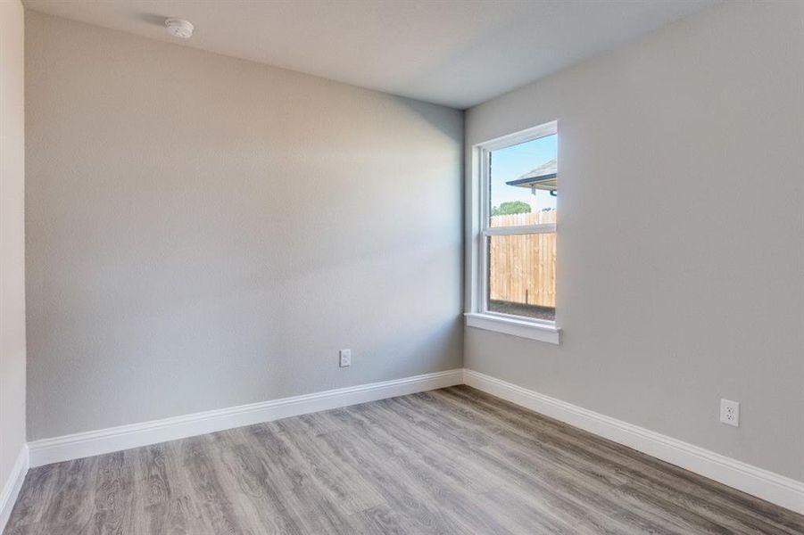 Unfurnished room with light wood-style floors and baseboards