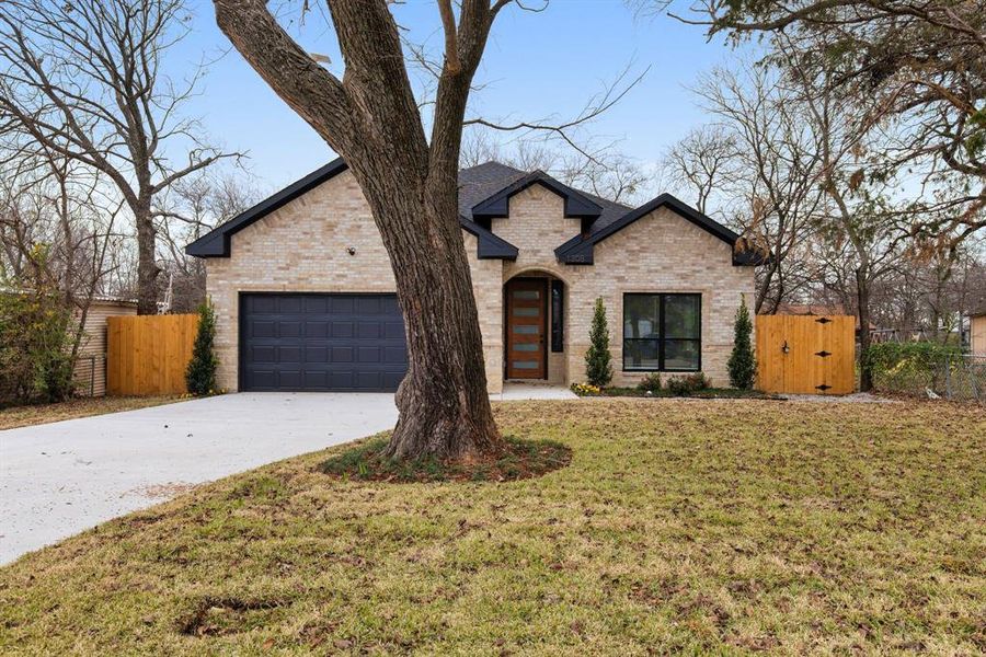 French country style house featuring a garage and a front yard