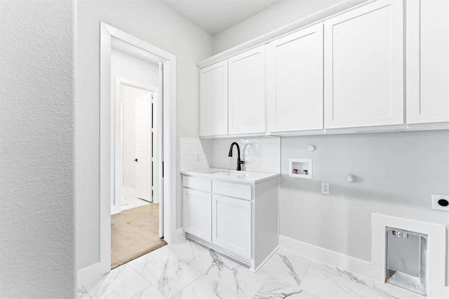 Washroom with hookup for a gas dryer, light marble finish flooring, cabinet space, washer hookup, and hookup for an electric dryer