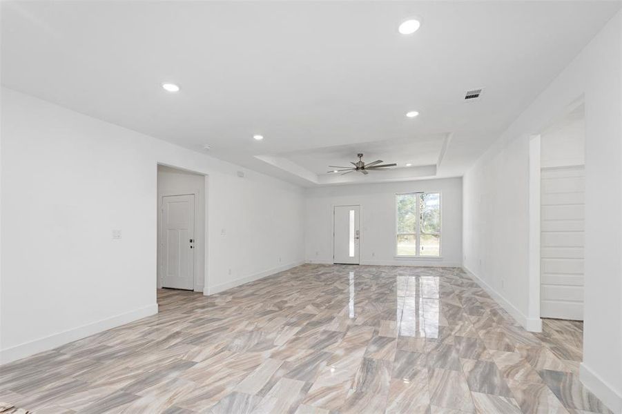 Spare room with a raised ceiling and ceiling fan