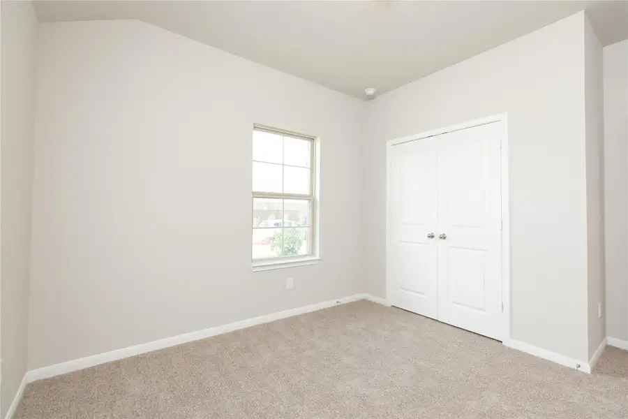 Generously sized secondary bedrooms featuring spacious closets, soft and inviting carpeting underfoot, large windows allowing plenty of natural light, and the added touch of privacy blinds for your personal retreat. Sample photo of completed home with similar floor plan. Actual colors and selections may vary.