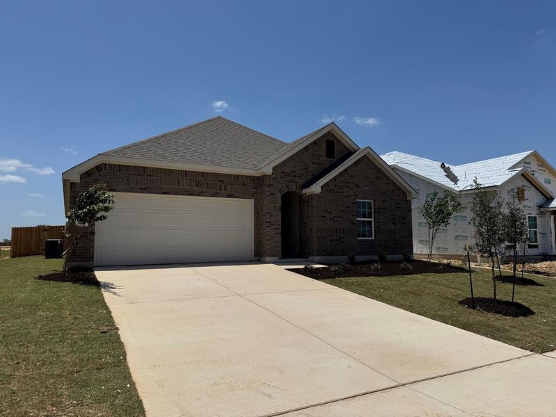 Ranch-style home with brick siding, a garage, concrete driveway, and a front yard Ranch-style home with brick siding, a garage, concrete driveway, and a front yard