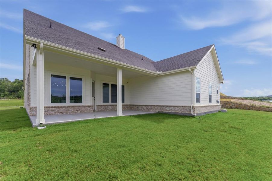 Covered patio featuring a solid roofline, white support columns, and a concrete surface Covered patio featuring a solid roofline, white support columns, and a concrete surface