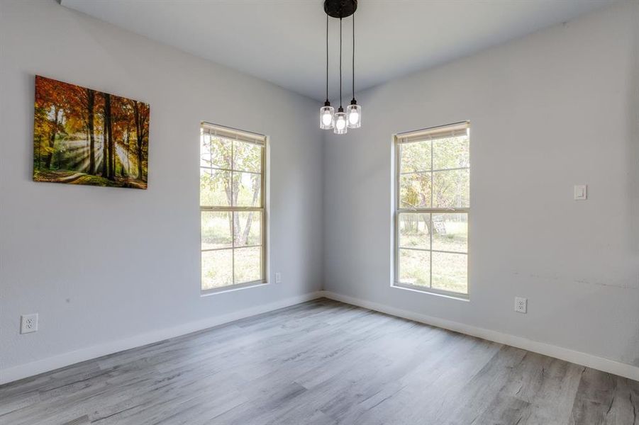 Unfurnished room with wood finished floors and a chandelier Unfurnished room with wood finished floors and a chandelier
