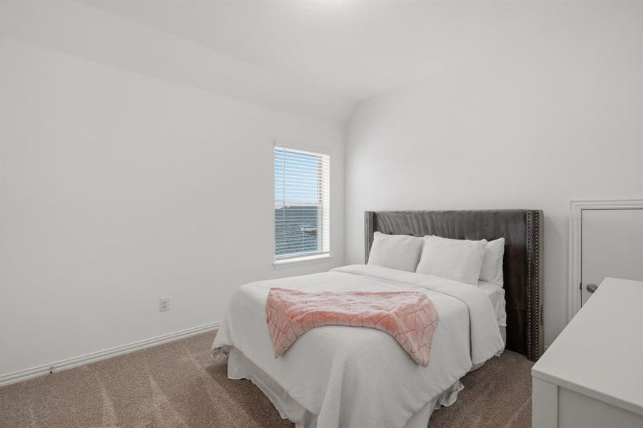 Bright secondary bedroom with neutral finishes, plush carpet, and flexible space for guests, kids, or a home office. Move-in ready and easy to personalize.