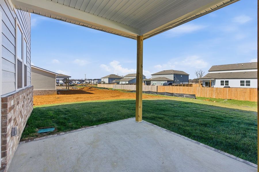 A yard with a fence and grass.