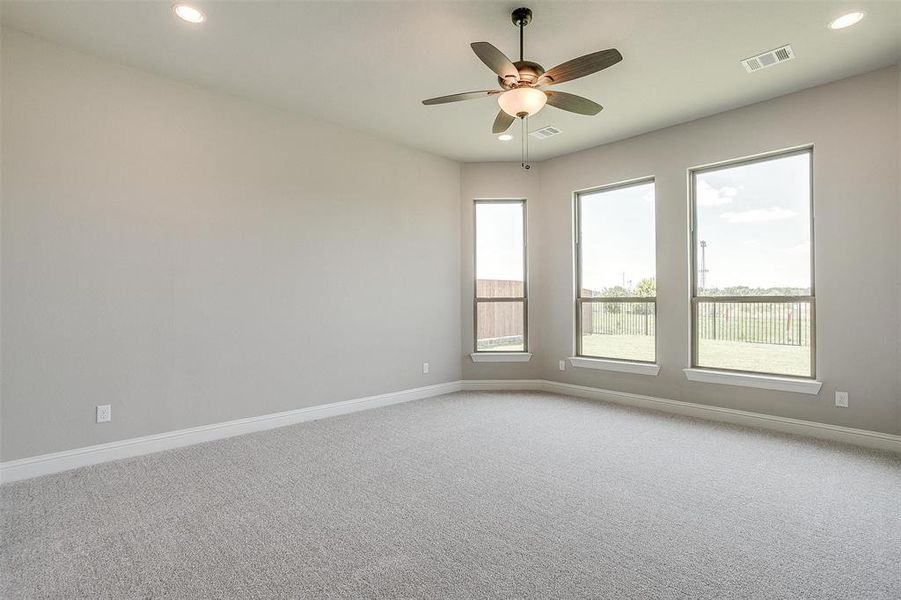 Carpeted spare room with ceiling fan