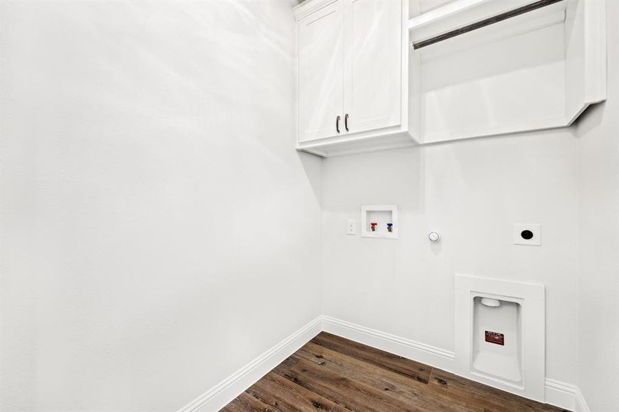 Clothes washing area with hookup for an electric dryer, washer hookup, hookup for a gas dryer, cabinets, and dark wood-type flooring