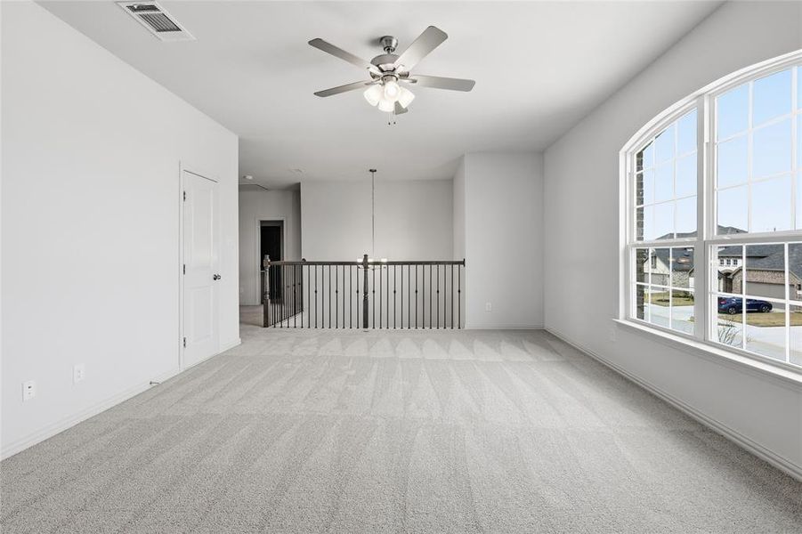 Spare room with a ceiling fan and light carpet