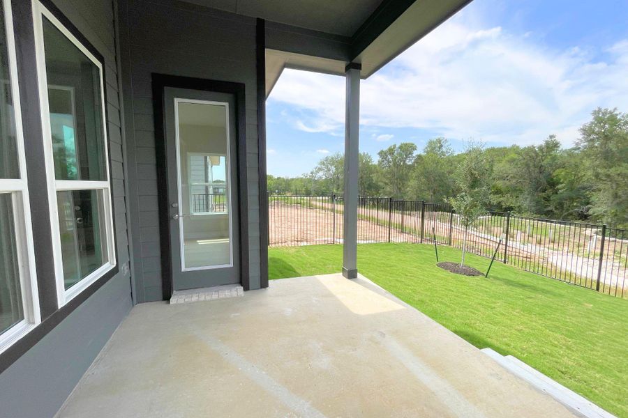 A spacious covered patio offers outdoor living with views of green space and a fenced yard.