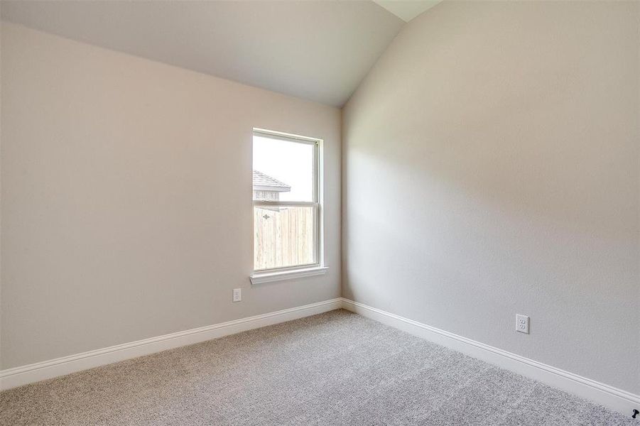 Carpeted spare room with lofted ceiling