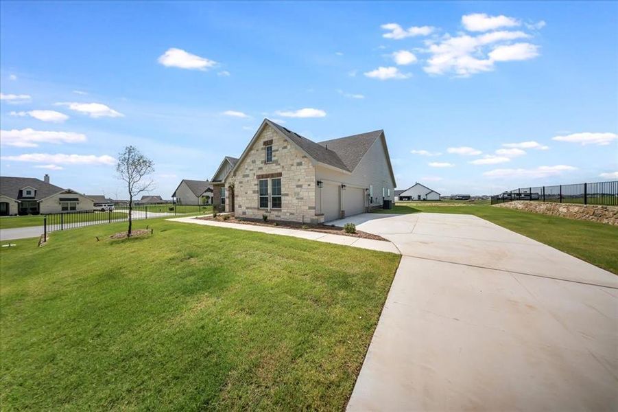 View of front of house featuring driveway, stone siding, and a garage View of front of house featuring driveway, stone siding, and a garage