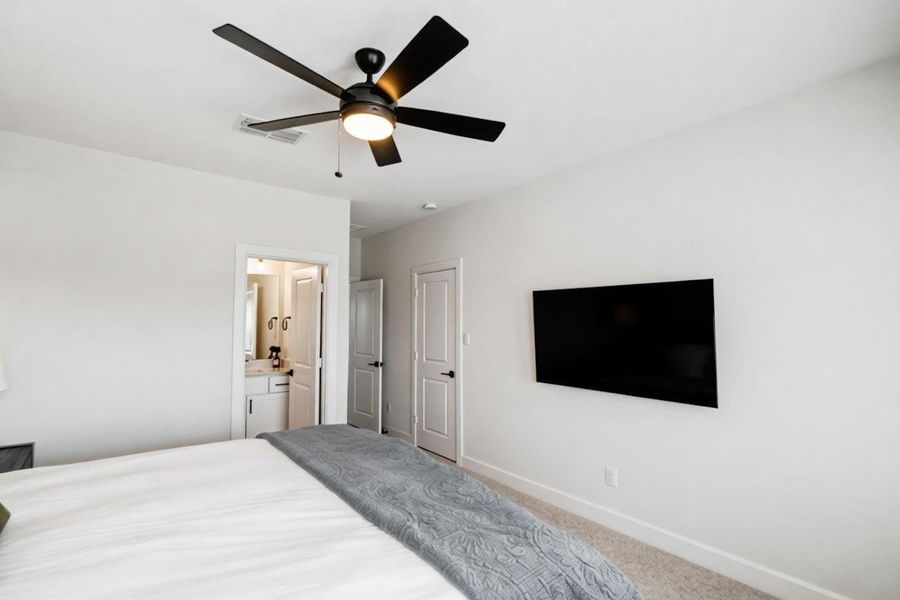 Upstairs secondary bedroom with en-suite bath access, offering a comfortable layout and functional privacy for guests or family.