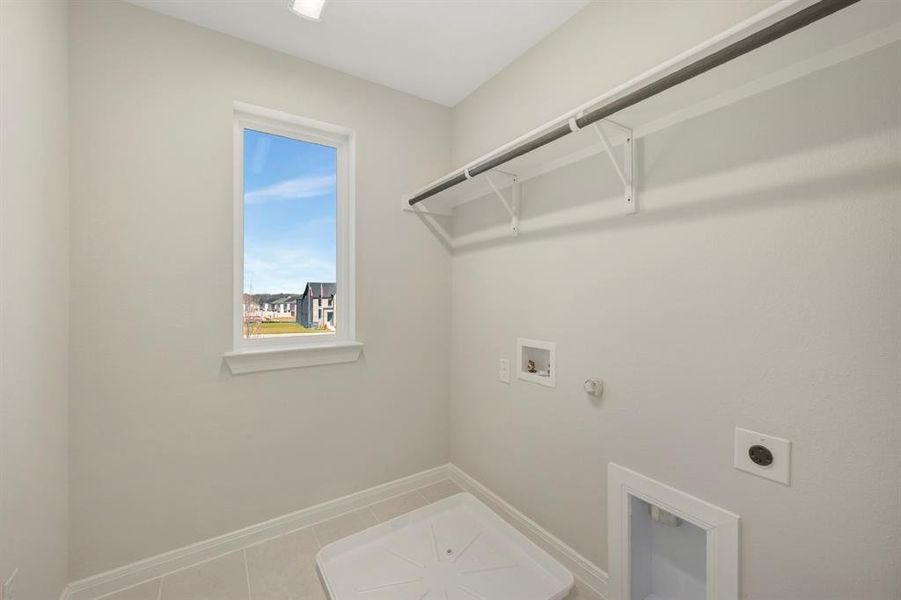 Laundry room featuring hookup for a gas dryer, electric dryer hookup, hookup for a washing machine, and light tile patterned floors