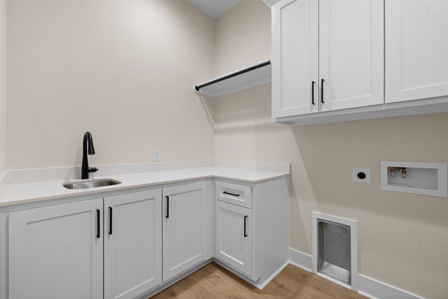 Laundry Room with tons of cabinets for storage along with a sink.