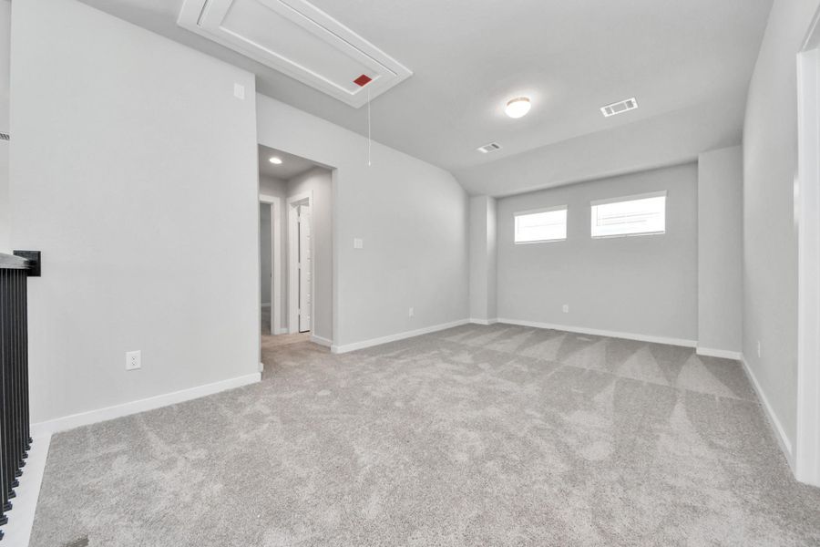 Ascend to relaxation in this fantastic game room! Ideal for both casual gatherings and adult gaming, it boasts plush carpet, lofty ceilings, custom paint, and ample windows for abundant natural light. Sample photo of completed home with similar floor plan. Actual colors and selections may vary.