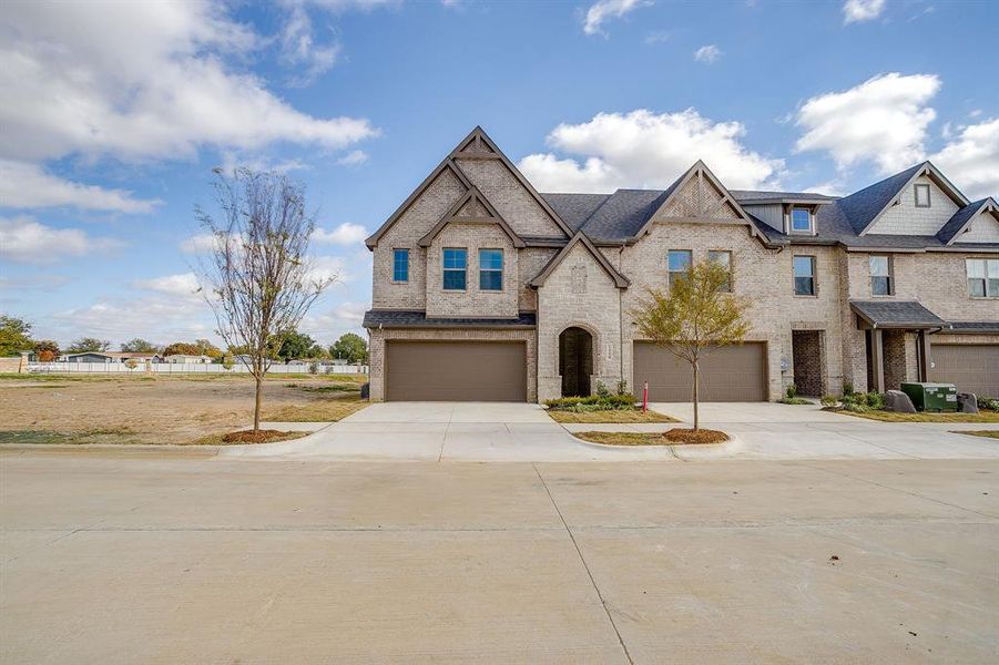 View of front of house featuring concrete driveway, brick siding, and a garage