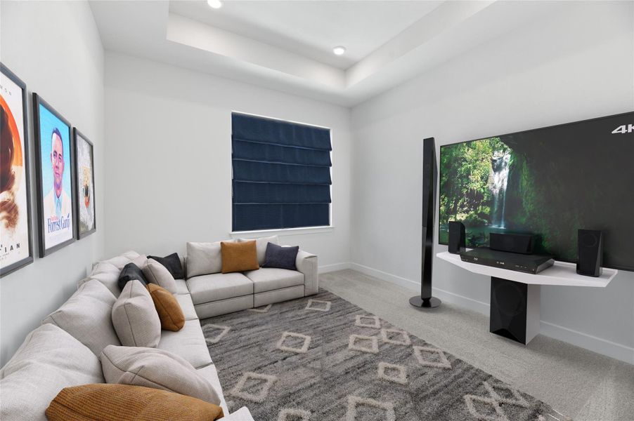Living area featuring carpet floors, a tray ceiling, and recessed lighting