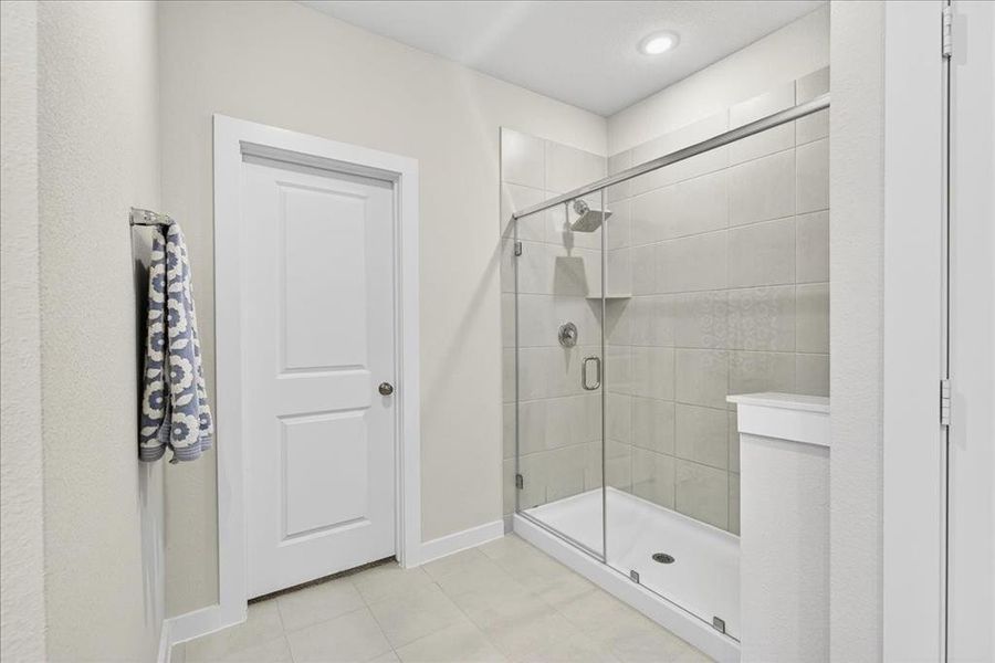 Primary bathroom featuring a stall shower and light tile patterned floors