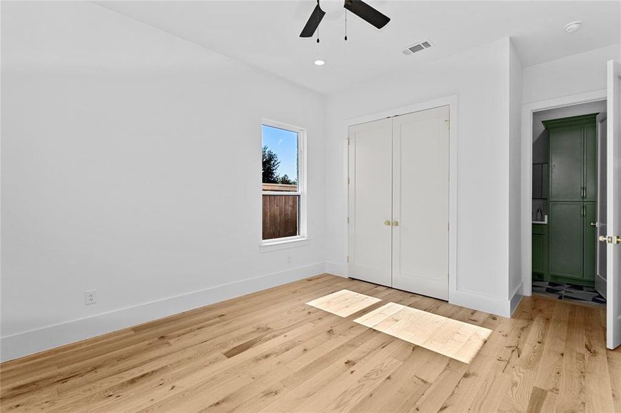 2nd Bedroom with full bathroom featuring light wood-type flooring, a closet, ceiling fan, and recessed lighting. Closet has custom shelving to the ceiling. Located on the 1st floor 2nd Bedroom with full bathroom featuring light wood-type flooring, a closet, ceiling fan, and recessed lighting. Closet has custom shelving to the ceiling. Located on the 1st floor