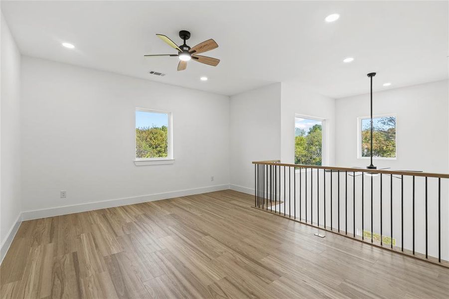 Spare room with ceiling fan, light wood-type flooring, and recessed lighting
