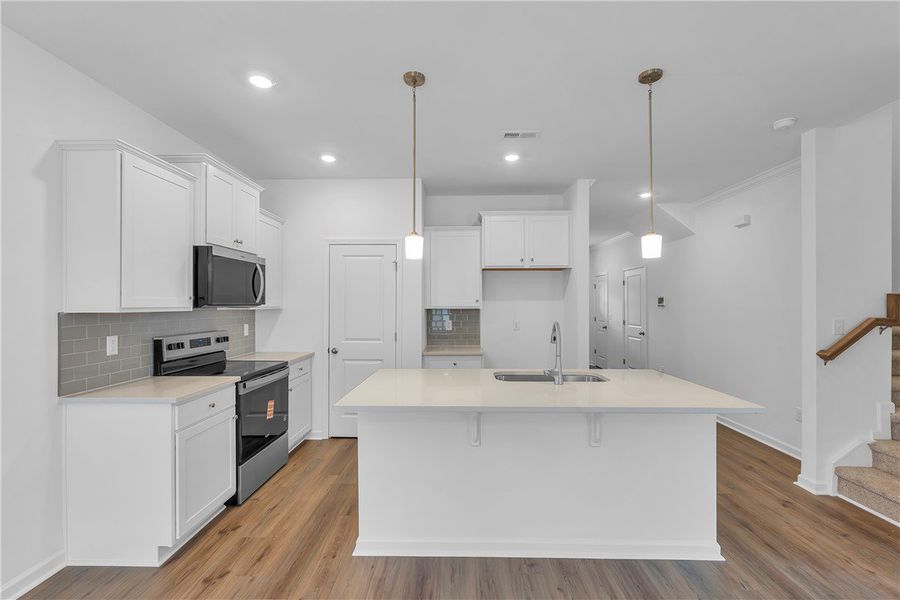 This modern kitchen features a spacious island and This modern kitchen features a spacious island and