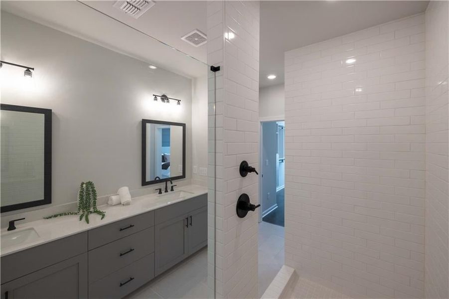 The primary bathroom shower and double vanity. *Please note that pictures shown are of the Jacobsen II floorplan but they are not of the actual home listed.