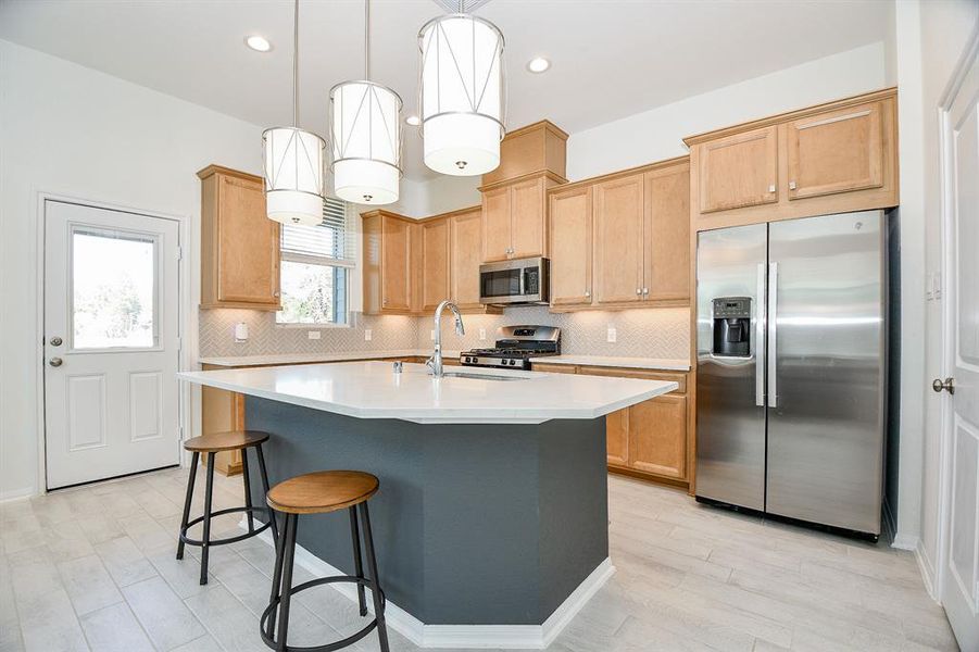 Show off your culinary skills in this beautifully appointed kitchen. An oversized contrasting island with stylish overhead lighting, offers ample workspace for meal prep and convenient bar seating for casual dining and entertaining.