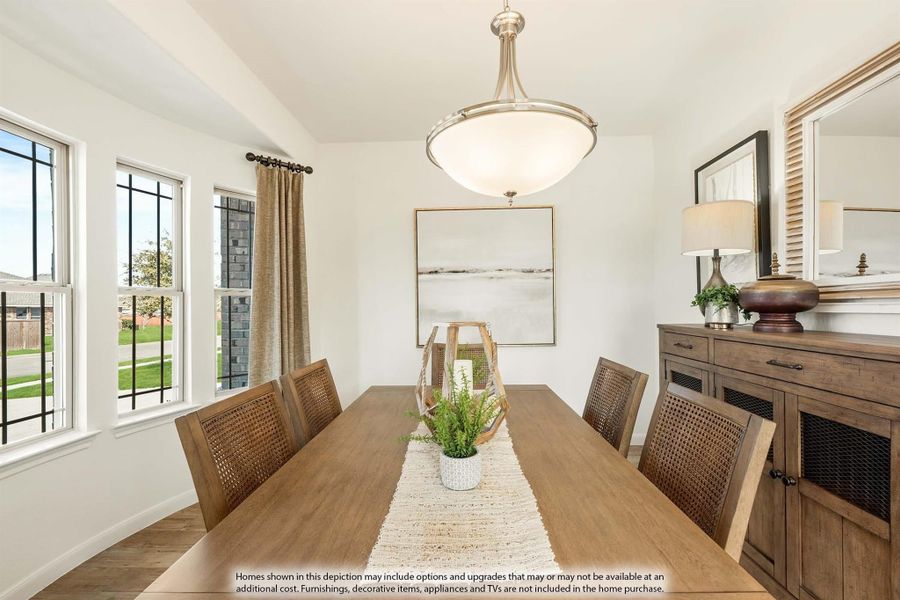 Dining room with wood table, woven chairs, pendant light, and wood sideboard beside large windows