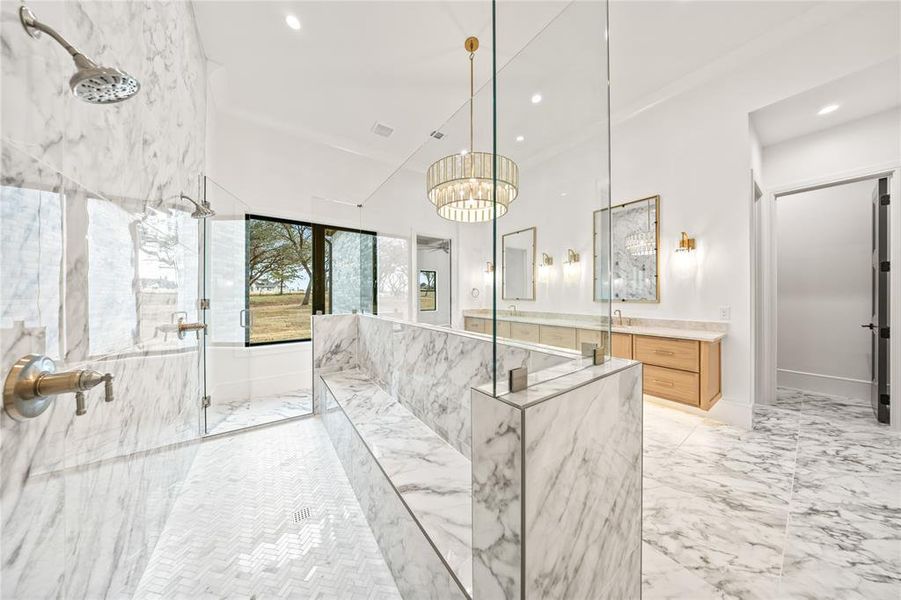 Full bathroom featuring a marble finish shower, vanity, light marble finish flooring, and recessed lighting
