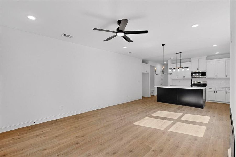 Unfurnished living room with light wood-type flooring, recessed lighting, and ceiling fan Unfurnished living room with light wood-type flooring, recessed lighting, and ceiling fan