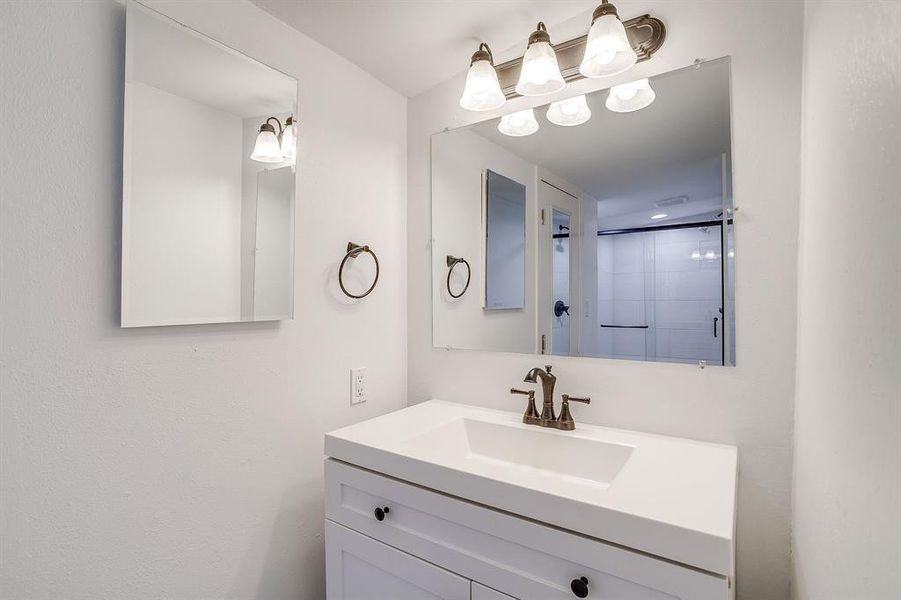 Full bathroom with vanity and a shower stall