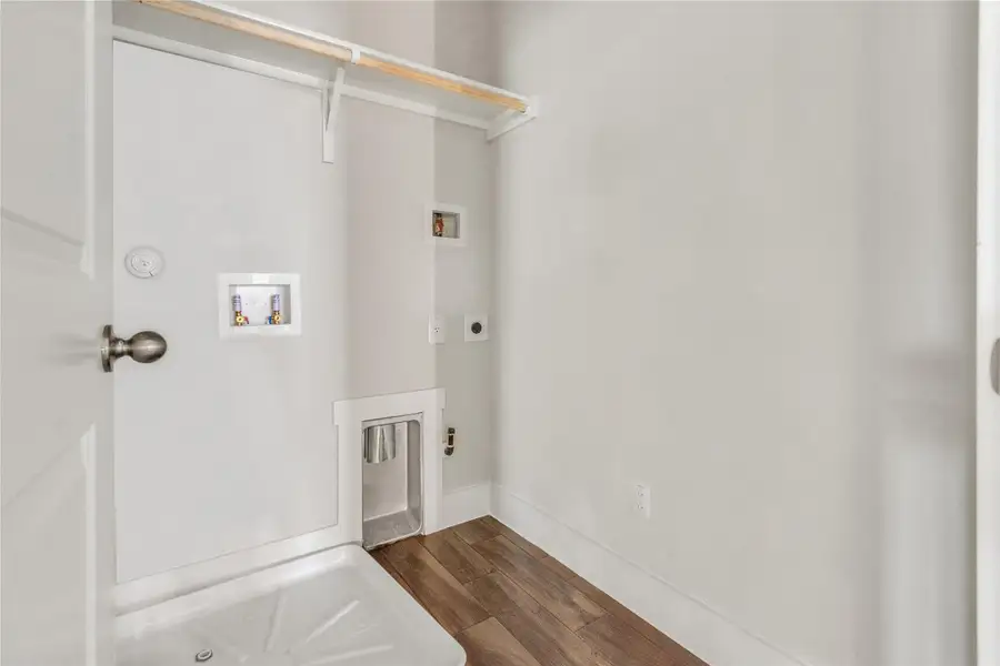 A dedicated laundry room with hookups and a convenient shelf for organizing.
